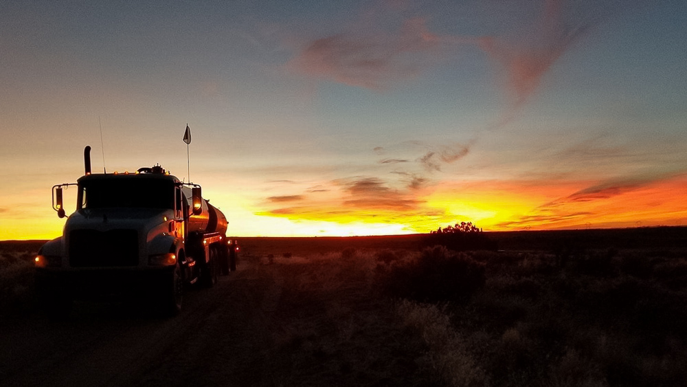 Water truck in front of sunrise/sunset